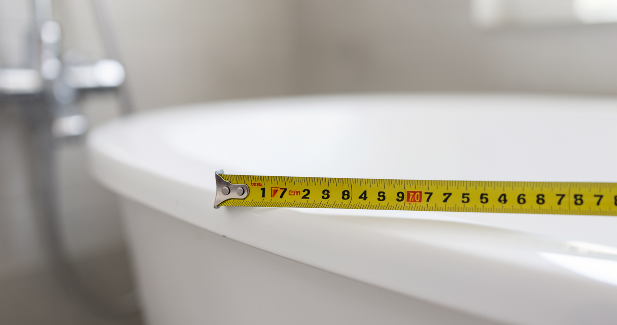 Mètre ruban mesurant la longueur et largeur d'une baignoire standard 170x75 cm